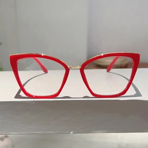Detail of red cat-eye glasses frame with elegant gold metal inlay on a white stand