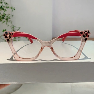 Detail of pink transparent cat eye glasses frame with red accents and leopard print