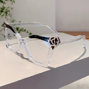 Detail of transparent cat-eye glasses frame with leopard print tips and gold G-logo