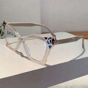 Macro detail of cat-eye glasses frame featuring blue tortoise pattern and cream temples