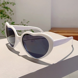 Détail de lunettes de soleil blanches en forme de cœur avec verres de protection UV