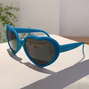 Vue détaillée des lunettes de soleil bleues en forme de cœur sur un support moderne