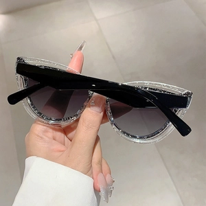 Detailed view of cat eye sunglasses featuring glittery frame and black lenses