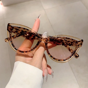 Fashion cat-eye sunglasses with tortoiseshell frame and gradient brown lenses in hand