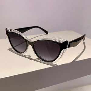 Detail of cat eye sunglasses with black frame and silver glitter transparent overlay