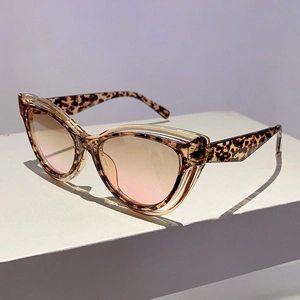 Detail shot of cat eye sunglasses with leopard pattern frame and pink gradient lenses