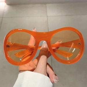 Nahaufnahme der leuchtend orangefarbenen Y2K Sonnenbrille mit transparentem Rahmen