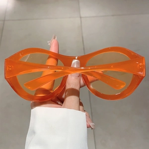 Detail der Y2K Oversize-Sonnenbrille in Orange mit glänzenden, breiten Bügeln und Design