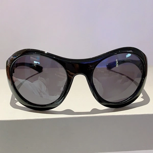 Detailansicht der schwarzen Oversize-Y2K-Sonnenbrille auf einem minimalistischen Display