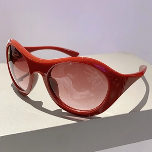 Detail einer roten Y2K-Sonnenbrille mit glänzendem Harzrahmen und getönten Gläsern
