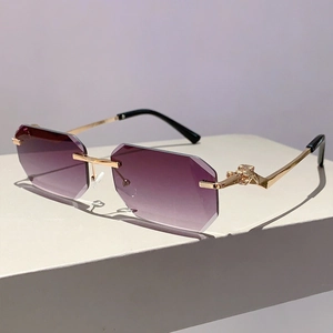 Detailed close-up of leopard head gold hardware on purple gradient rimless sunglasses