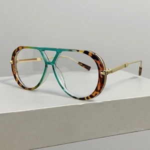 Detail view of tortoiseshell and green leopard print eyewear with golden metal temples