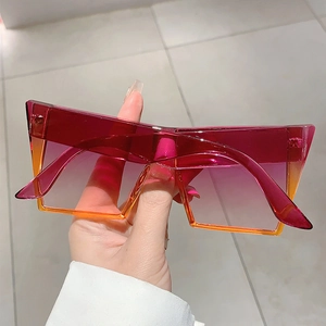 Détail macro de lunettes de soleil carrées oversize avec monture rose pêche transparente