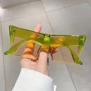 Détail de lunettes de soleil carrées surdimensionnées vert néon avec verres orange
