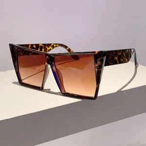 Détail de lunettes de soleil carrées oversize imprimé léopard avec verres dégradés