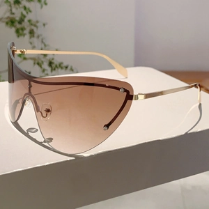 Détail de lunettes de soleil masque avec verres dégradés et branches dorées