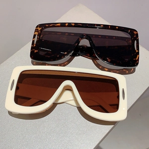 Detail of oversized shield sunglasses in tortoiseshell and beige with metal accents