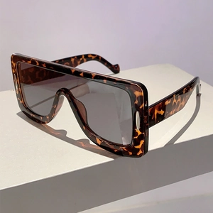 Detail of tortoise shell oversized flat top sunglasses with silver metal accents on the frame