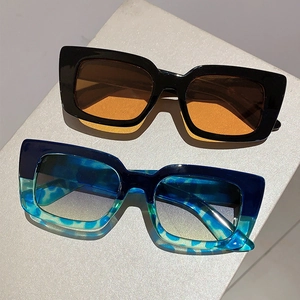 Detail of modern rectangular thick frame sunglasses in black and tortoiseshell finish