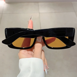 Detail of vintage rectangular sunglasses with black frame and amber lenses
