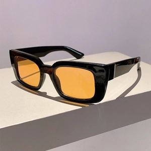 Close-up of vintage square black frame sunglasses with bright orange translucent lenses