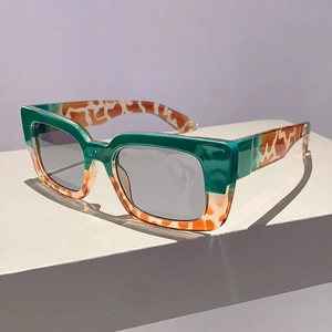 Detail view of retro square two-tone sunglasses with green frame and tortoiseshell temples