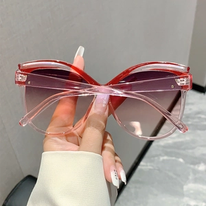 Detail view of pink butterfly frame sunglasses with gradient purple lenses and metal hinge