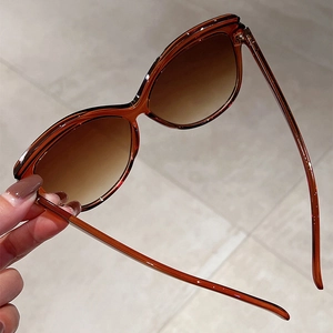Detail of oversized butterfly sunglasses with amber tortoiseshell frames and gradient lenses