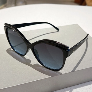 Detail of oversized butterfly cat-eye sunglasses with gradient lenses and metal rivets
