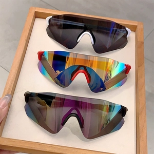 Close-up of three cycling sunglasses in white, red, and black on a wooden tray