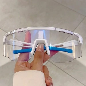 Detailed view of white sports goggles with blue non-slip temples and clear protective lens