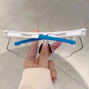 Close-up of white sports sunglasses featuring blue rubber ear tips and a black nose pad