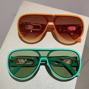 Detail of oversized sunglasses with metallic gold temple accents and gradient lenses