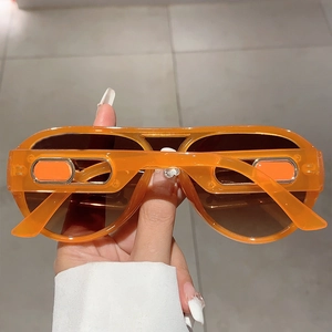 Detail view of retro aviator sunglasses with translucent orange frame and gradient lenses