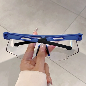 Detail view of blue and black sports goggles with panoramic clear lenses and matte frame