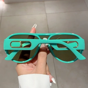 Detail of mint green sunglasses with stylish gold metal hollow temple decoration