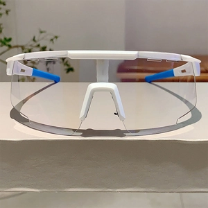 Close-up of white sports cycling glasses with transparent lens and blue non-slip temple tips