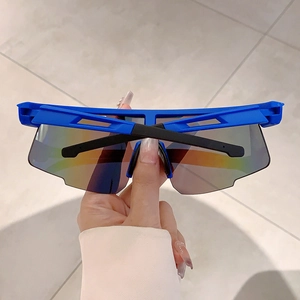 Gros plan de lunettes de sport bleues avec verres irisés et monture enveloppante