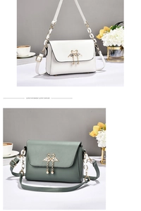 Detail of elegant crossbody bag with swan heart clasp and pearl metal tassels