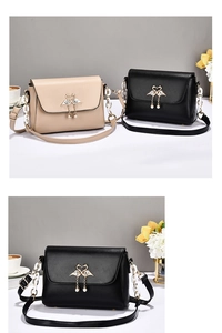 Detail of crossbody bag with swan-shaped metal clasp and elegant pearl fringe tassel