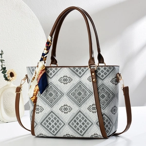 Elegant large tote bag with geometric print and silk scarf decor in a minimalist setup