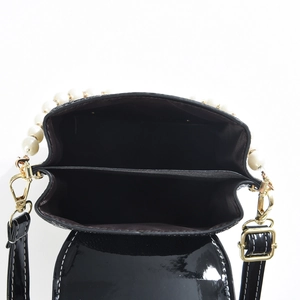 Glossy black patent leather shoulder bag with faux pearl strap and dual compartments