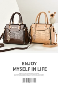 Close-up of crocodile pattern leather texture with metal leaf pendant on handbags