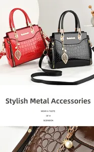 Detail of elegant crocodile texture and golden leaf pendant with pearls on luxury handbag