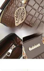 Detailed macro view of brown crocodile texture leather and golden leaf pendant on a handbag