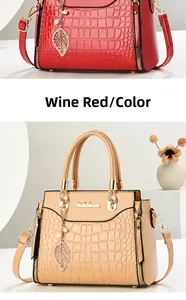 Detailed view of crocodile pattern faux leather and golden leaf pendant on handbags