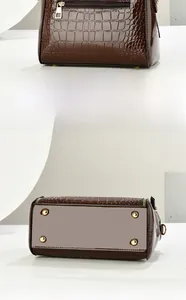 Detail view of brown crocodile pattern tote featuring back zipper and gold metal studs