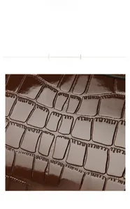 Close-up of brown crocodile texture PU leather with polished finish and embossed details
