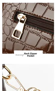 Macro detail of brown crocodile texture bag with gold zipper and metal shoulder strap clasp