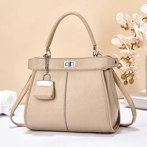 Elegante beige schoudertas van generfd leer met handvat en zilveren draaisluiting